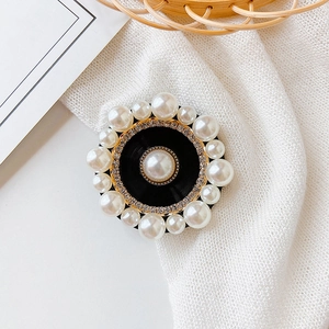 Close-up of pearl and rhinestone phone grip holder on white knit fabric background
