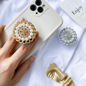Detailed view of pearl and rhinestone floral phone socket on a white background