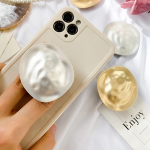 Detail of creative wavy metal phone grip with gold and silver matte hammered texture