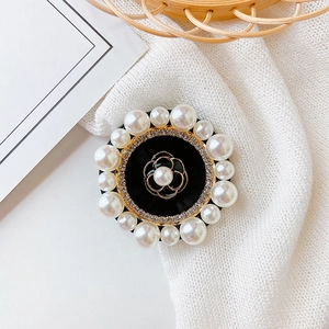 Detailed view of elegant camellia phone grip with pearls and rhinestones on a table