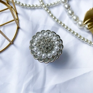 Detail of floral phone socket with pearls and rhinestones on elegant silk background