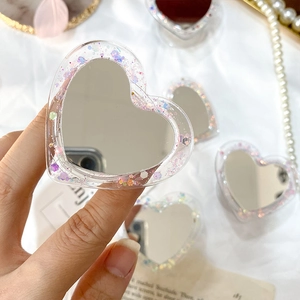 Détail d'un support de téléphone pailleté en forme de cœur avec miroir et sequins violets