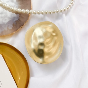 Macro shot of gold plated irregular hammered disc mount for adjustable mobile phone stands