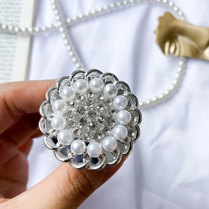 Detailed close-up of a floral phone grip featuring elegant white pearls and sparkling rhinestones