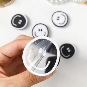 Detail of peeling protective film from a white round smiley face phone socket grip