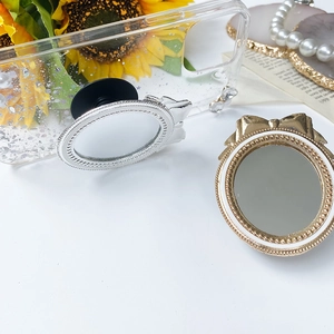Detail of vintage bow mirror phone socket stand with pearls on a glittery case