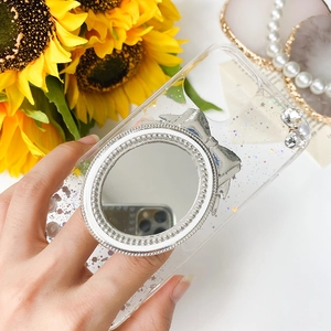 Close-up of glitter phone case with rhinestone mirror stand and silver bow detail