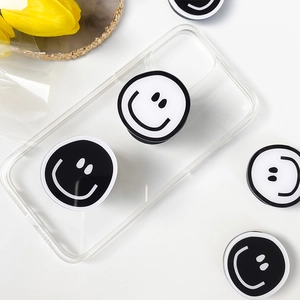 Close-up of DIY minimalist smiley face phone grip on clear case with lifestyle background