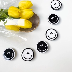 Detail shot of black and white smiley face phone grips with yellow tulip decor