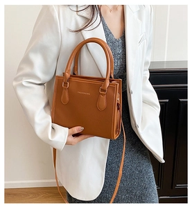 Close-up of brown litchi pattern PU leather handbag with fashion and bag gold lettering