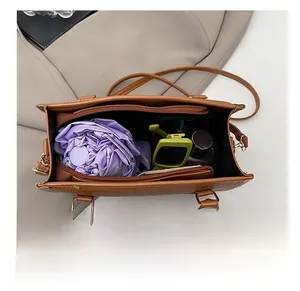 Detail view of large brown pebble leather tote interior with umbrella and accessories