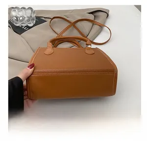 Detailed close-up of durable base and litchi texture on brown leather handbag