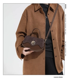 Close-up of brown patchwork leather bag with metal turn-lock and adjustable strap