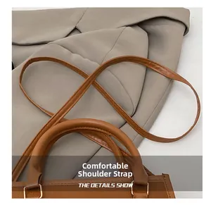 Detail of soft leather tote handle and comfortable shoulder strap in dark brown finish