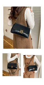 Détail d'un sac en cuir noir texturé avec boucle géométrique dorée et bandoulière chaîne