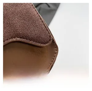Detail of the brown contrast stitching and premium matte suede texture on the handbag