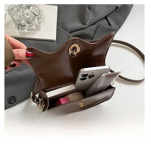 Detail view of the vintage brown shoulder bag showing spacious interior and golden clasp