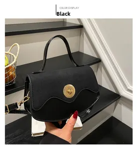 Close-up of black retro shoulder bag featuring gold twist lock and mixed material texture