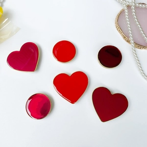 Dettaglio di supporti fai-da-te a cuore rosso con bordi dorati e finitura smaltata