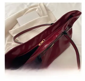 Macro shot of smooth gold zipper and burgundy oily wax leather texture on tote bag