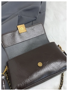 Détail du sac à bandoulière en cuir ciré marron avec boucle magnétique dorée