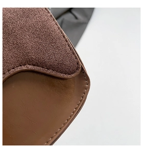 Detailed macro view of the brown leather and suede texture with stitching on this handbag