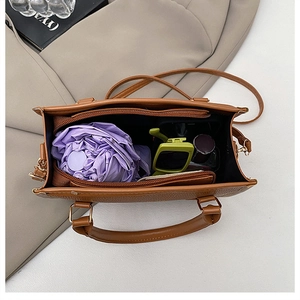 Internal view of brown leather handbag showing large capacity for umbrella and mirror