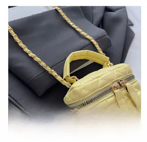 Detail of yellow quilted mini box bag with gold-tone hardware and chain strap