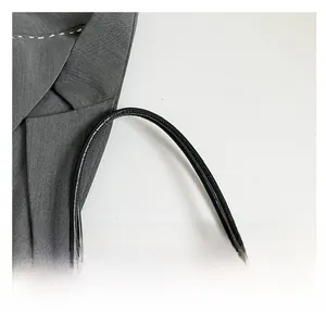 Detail of black glossy leather handle with gold hardware and checkered pattern tote