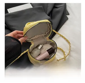 Detail shot of a yellow quilted mini bag interior showing capacity for cosmetics and lipstick