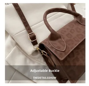 Détail de la boucle métallique ajustable et du fermoir mousqueton du sac à main brun