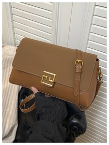 Détail d'un sac à main vintage en cuir marron avec un fermoir métallique carré doré chic