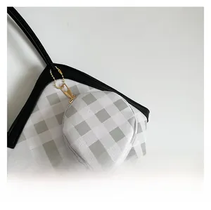 Close-up of checkered fabric tote bag with gold zipper and detachable coin purse