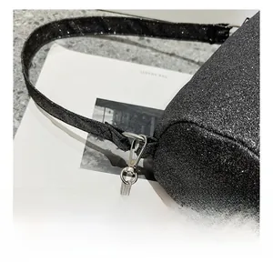Dettaglio del gancio metallico argento e della catena sulla borsa boston con paillettes