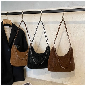 Close-up of hobo shoulder bags in leopard print with metal chain and velvet texture