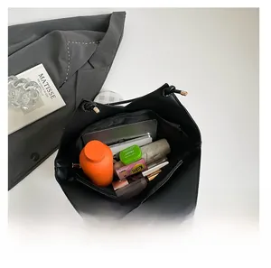 Detailed interior of large black tote bag showing capacity for laptop, water bottle and umbrella