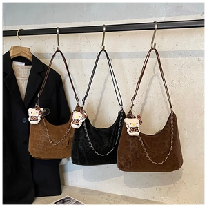 Close-up of leopard print hobo bags with metal chain straps and plush charm detail