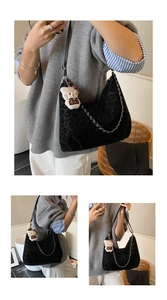 Detail of black leopard embossed suede tote bag with silver chain and plush charm