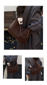 Detail of a leopard print hobo bag featuring gold chain decor and a cute plush charm