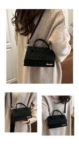 Détail du sac bandoulière en velours léopard noir avec logo doré et poignée