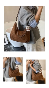 Detail of leopard print hobo bag with plush charm and metal chain on suede texture
