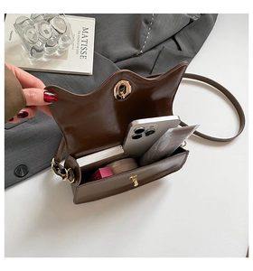 Brown leather crossbody bag showing internal capacity for phone and cosmetics
