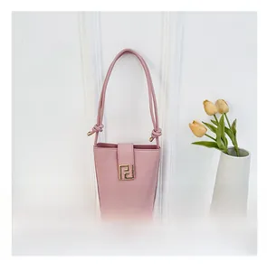 Pink leather bucket bag with gold FF clasp and thin shoulder strap in a lifestyle setting