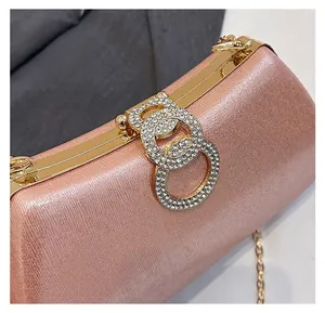 Detail of rose gold evening clutch with sparkling double ring rhinestone clasp and chain