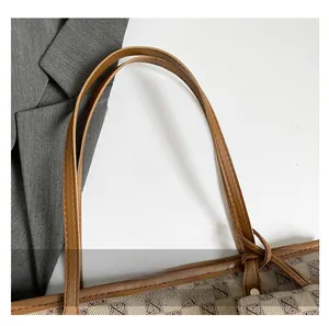 Close-up of brown leather handles with precise stitching and Monogram pattern fabric