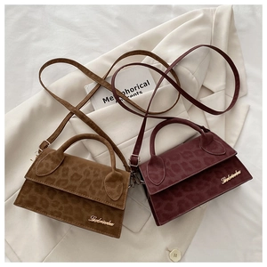 Gros plan sur la texture léopard et le logo doré des sacs à main en cuir vintage