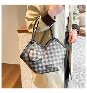 Detail of checkered tote bag with V-shaped cut, slim leather handles and round coin purse