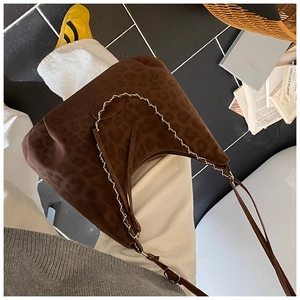 Close-up of leopard print suede shoulder bag with white contrast stitching details