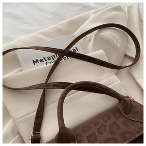 Détail du sac bandoulière marron vintage avec rabat léopard et boucles dorées