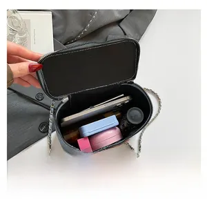 Interior capacity of gray woven small square bag showing phone and lipstick space
